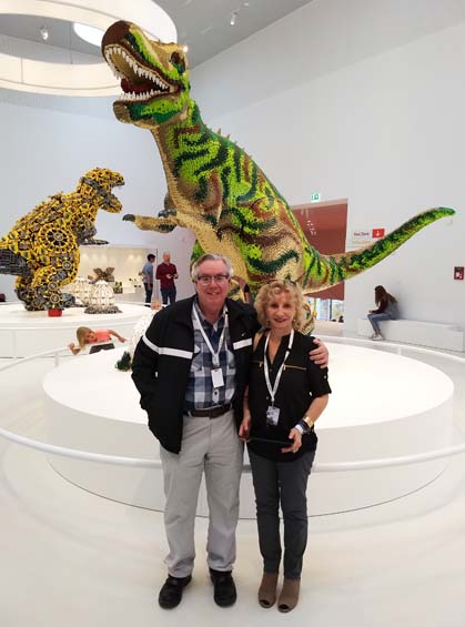 Larry and Eliska in front of the System Dinosaur at LEGO House